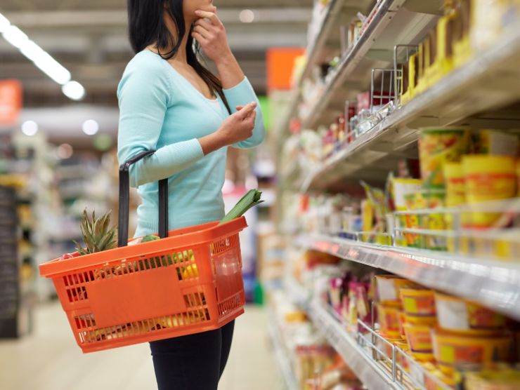 donna al supermercato che sceglie tra gli scaffali